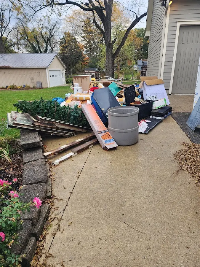 Dumpster being loaded with debris for Estate Cleanout Dumpster Rental in Napoleon